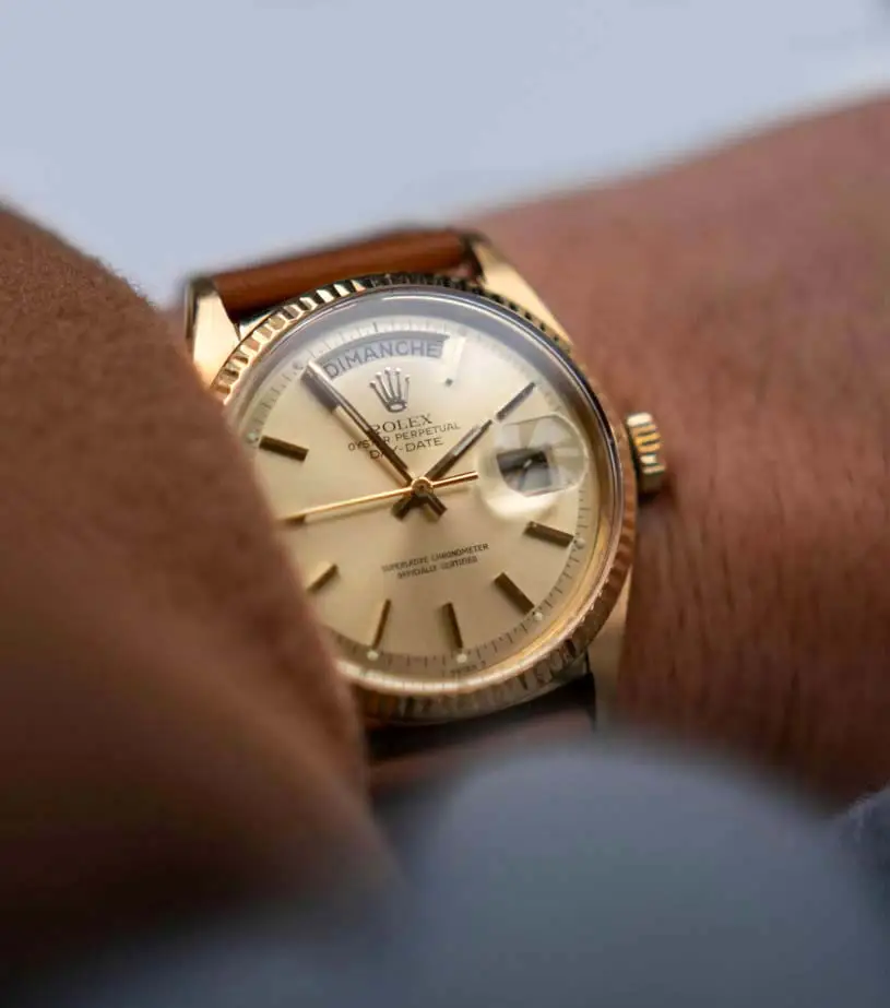 Rolex Day-Date en or au poignet, cadran champagne et index bâtons